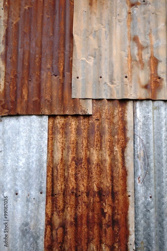 Rusted corrugated zinc sheets overlapping to form a fence