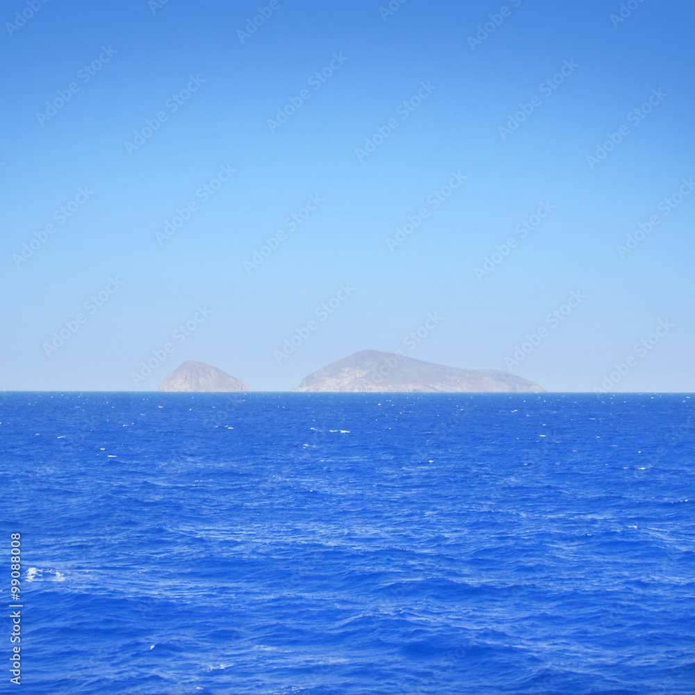 Clear and peaceful sea in Greece with islands on background.