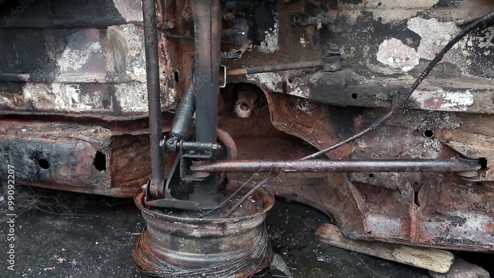 Burnt car lying on its side. Inverted burnt car Burnt car lying on its side. Inverted burnt car
