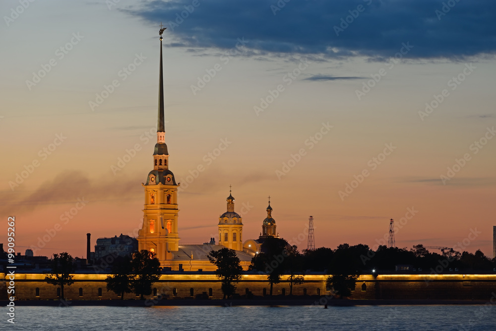 Peter and Paul fortress illuminated at sunset, the reflection 