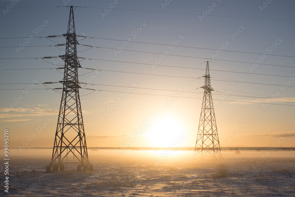 power lines in fog in winter on sunset