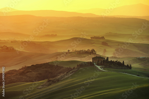Tuscany spring, rolling hills on misty sunset. Rural landscape.