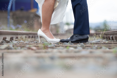 Hochzeitspaar auf Gleisen Brautschuhe Bräutigam Paarshooting