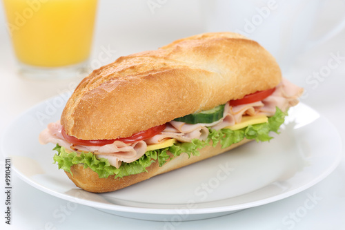 Sandwich Baguette belegt mit Schinken zum Frühstück mit Orange