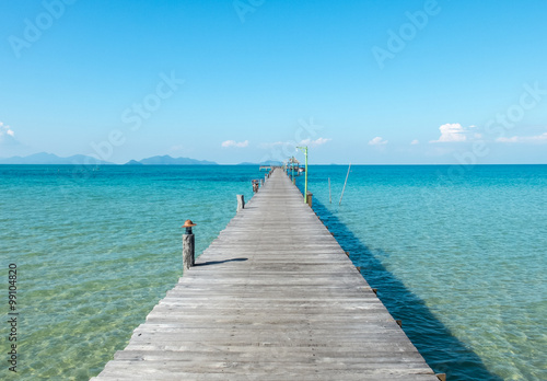 Vacation Time Concept, Wooden Path Between Crystal Clear Blue Sea and Sky from Beach of Island to The Pier in Thailand