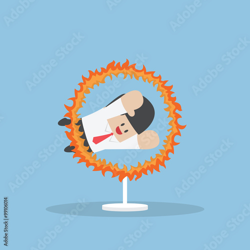 Businessman jumping through the fire hoop