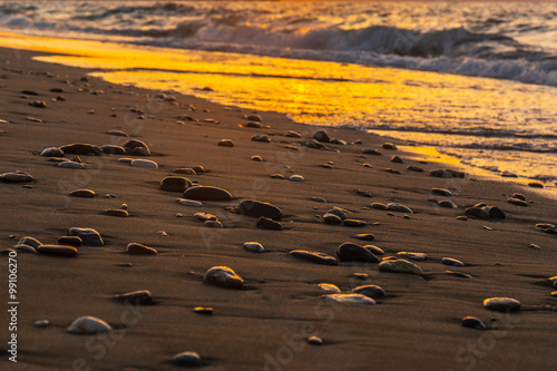 A beautiful beach on a Greek island in summer, under warm evening light