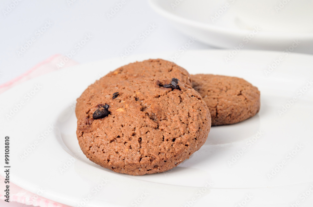Closeup chocolate cookie on white dish Closeup chocolate cookie on white dish