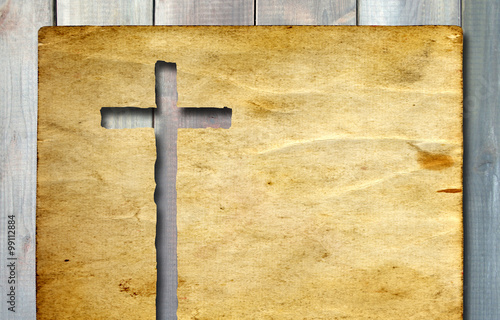 Old vintage Christian paper cross on wood background