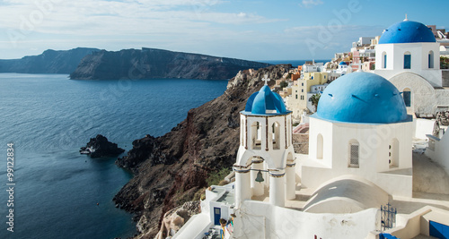 Blue-domed Greek Orthodox churches overlooking the Aegean Sea in Oia town on the island of Santorini, Greece