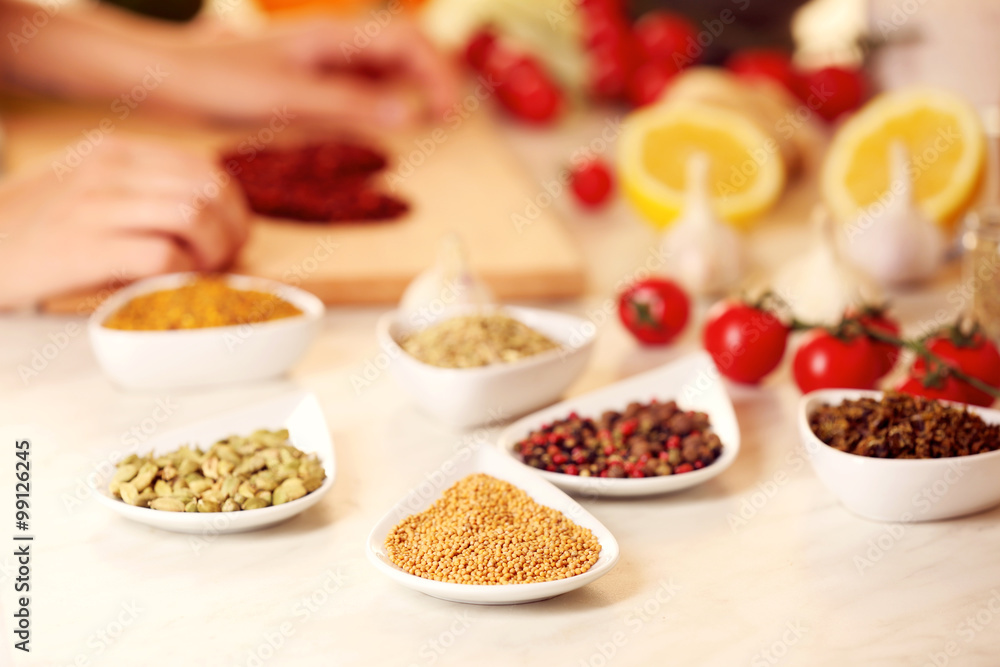 Variety of spices in ceramic containers on the kitchen table Variety of spices in ceramic containers on the kitchen table