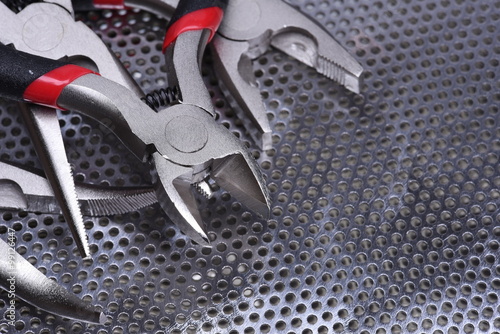 Fotografía Electrical tools wire cutter, pliers on metal background