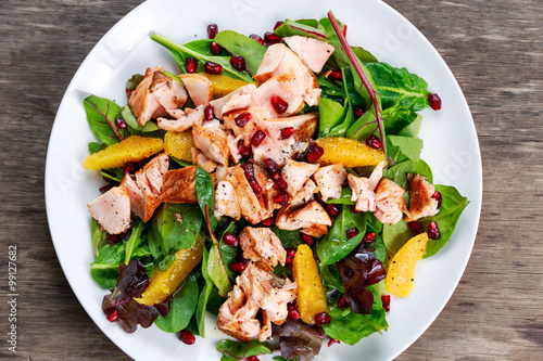 Fresh Salmon Salad with vegetables, pomegranate and orange.