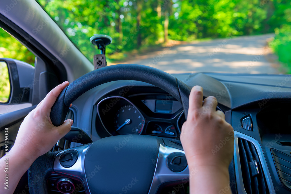 Women's hands holding the steering wheel of a vehicle