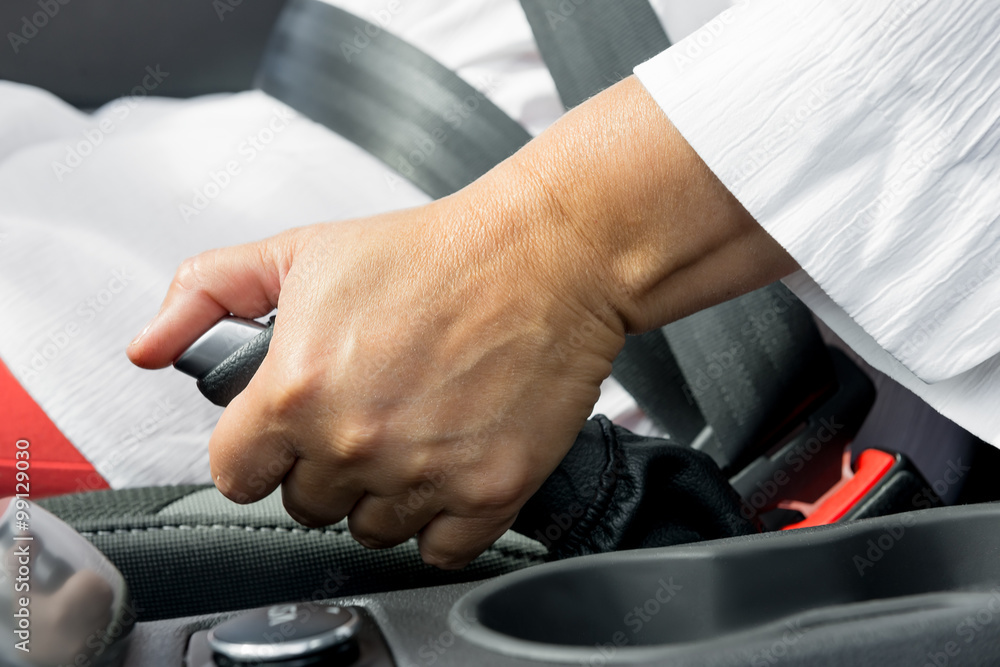 woman's hand and the hand brake of the car close-up