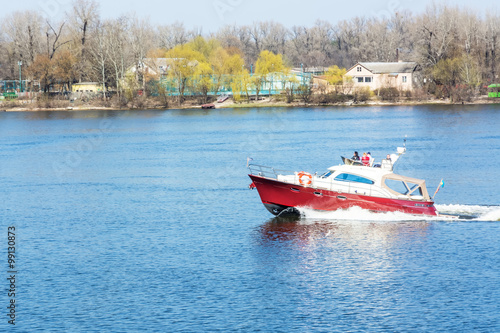 Red White boat floating on the river.