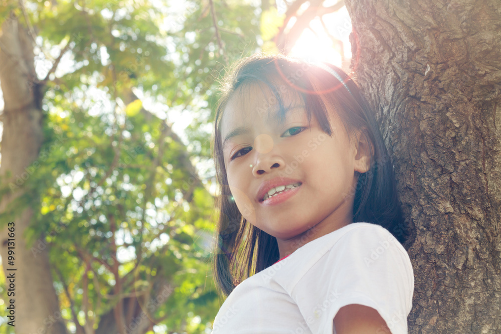 Close up happy adorable asian children climbing trees with sun flare. Close up happy adorable asian children climbing trees with sun flare.