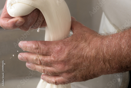 close up of hands doing a mozzarella in a dairy