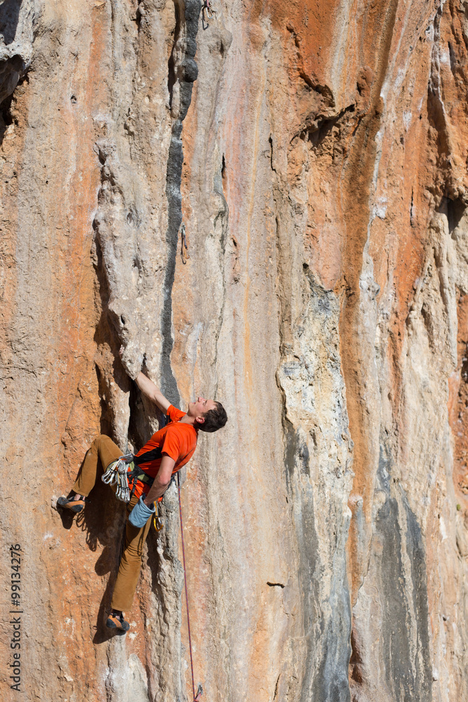 Young male climber hanging by a cliff. Young male climber hanging by a cliff.