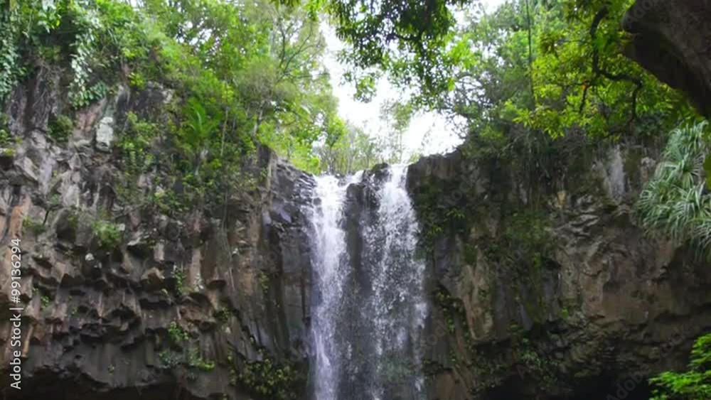 Tropical Waterfall in Lush Green Hawaiian Jungle. Adventure Leisure Vacation Slow Motion Tropical Waterfall in Lush Green Hawaiian Jungle. Adventure Leisure Vacation Slow Motion