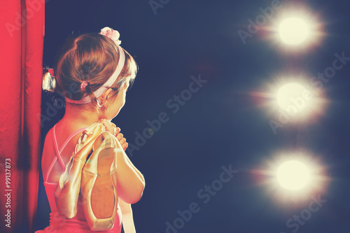 little girl ballerina ballet dancer on stage in red side scenes
