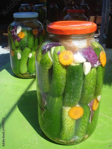 Canvastavla Homemade pickles in big jars on outdoor table in the sunlight