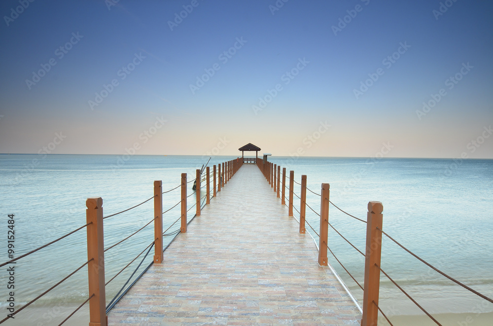 long pier heading to the sea under the beautiful blue sky.