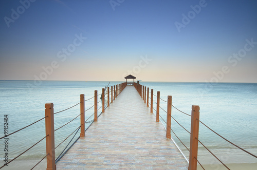 long pier heading to the sea under the beautiful blue sky.