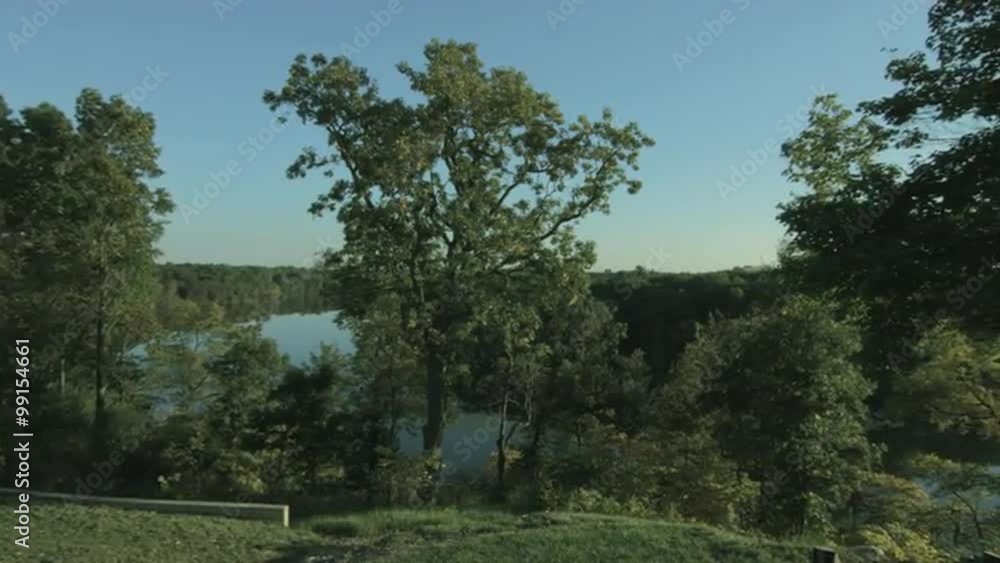 Pan from left to right across a scenic, fall view of the Huron River in Michigan, USA. Wide angle lens with sun shining through trees. Originally recorded in 4K, UHD. Pan from left to right across a scenic, fall view of the Huron River in Michigan, USA. Wide angle lens with sun shining through trees. Originally recorded in 4K, UHD.