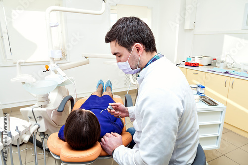 Dentist. Examining a patients teeth in the dentists chair at the