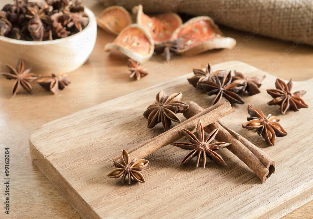 Star anise and cinnamon sticks on wooden chopping block Star anise and cinnamon sticks on wooden chopping block