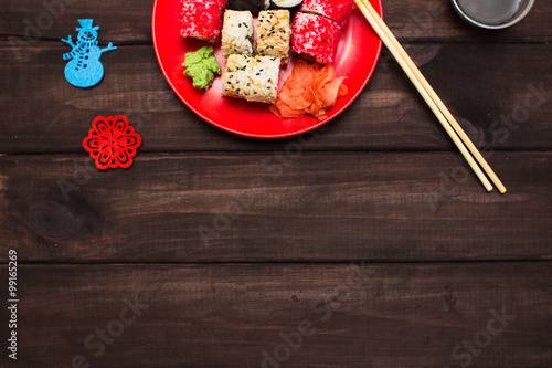 delicious rolls and sushi. Christmas decor on a wooden board