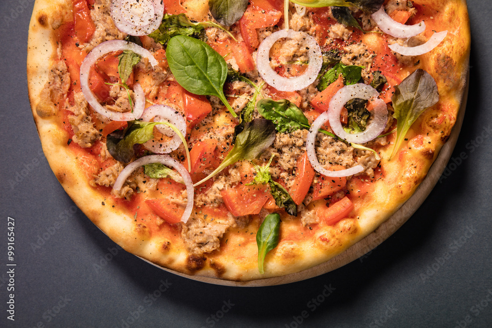 Pizza with tuna and vegetables served on wooden table Pizza with tuna and vegetables served on wooden table