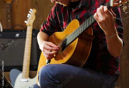 Young man playing acoustic guitar.