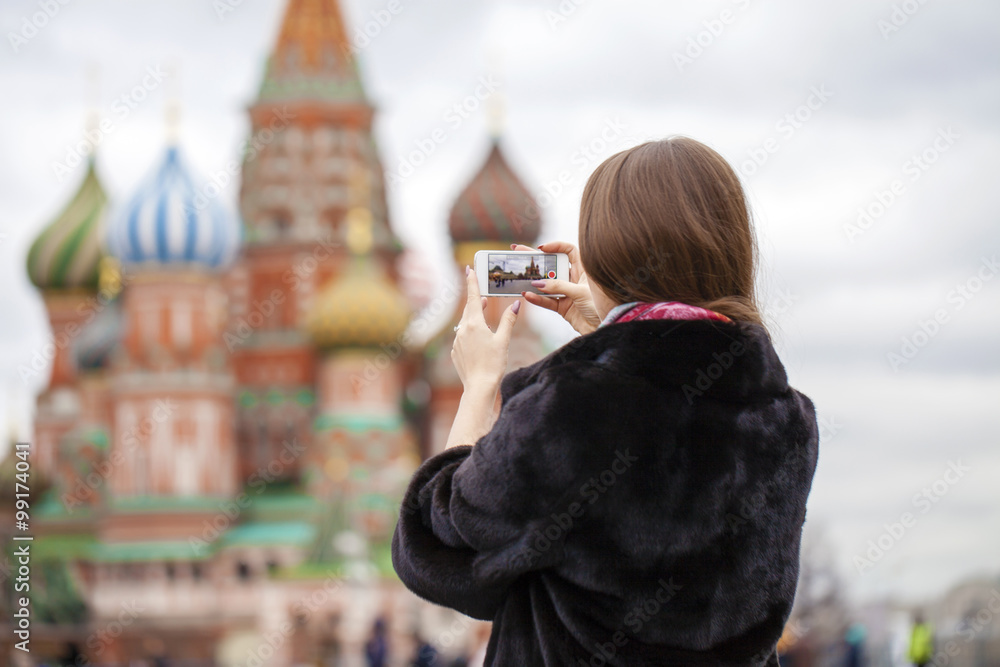 Naklejka premium Young beautiful woman tourist taking pictures on mobile phone
