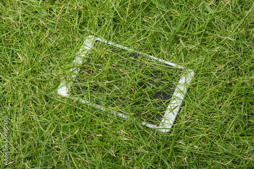 Tablet lying on the green grass