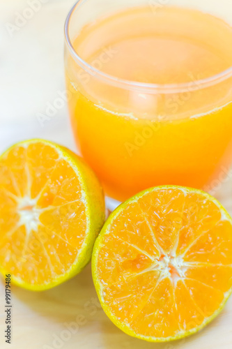 Glass of fresh tangerine, orange juice with sliced orange half o