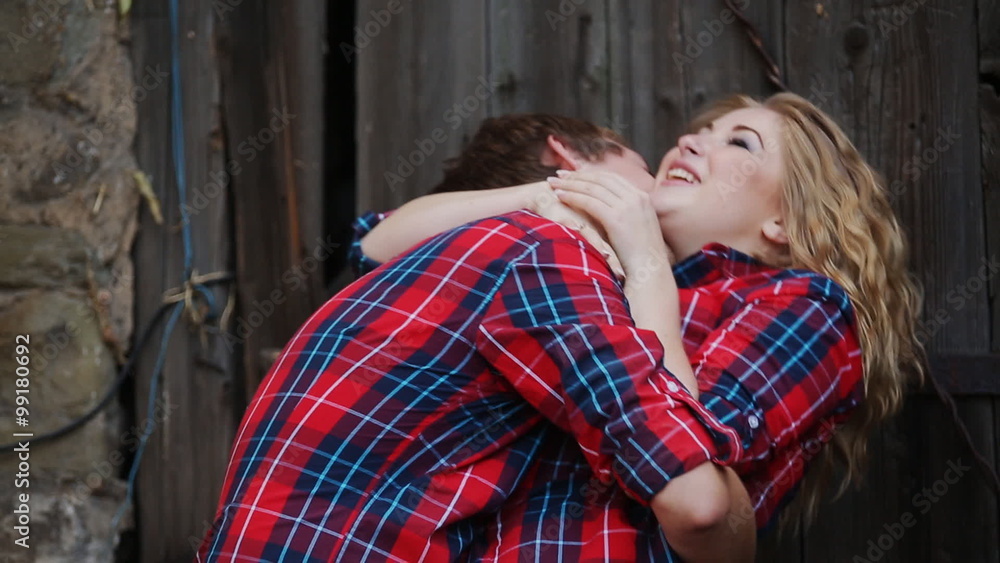 man kissing a beautiful girl on a background of an old door man kissing a beautiful girl on a background of an old door