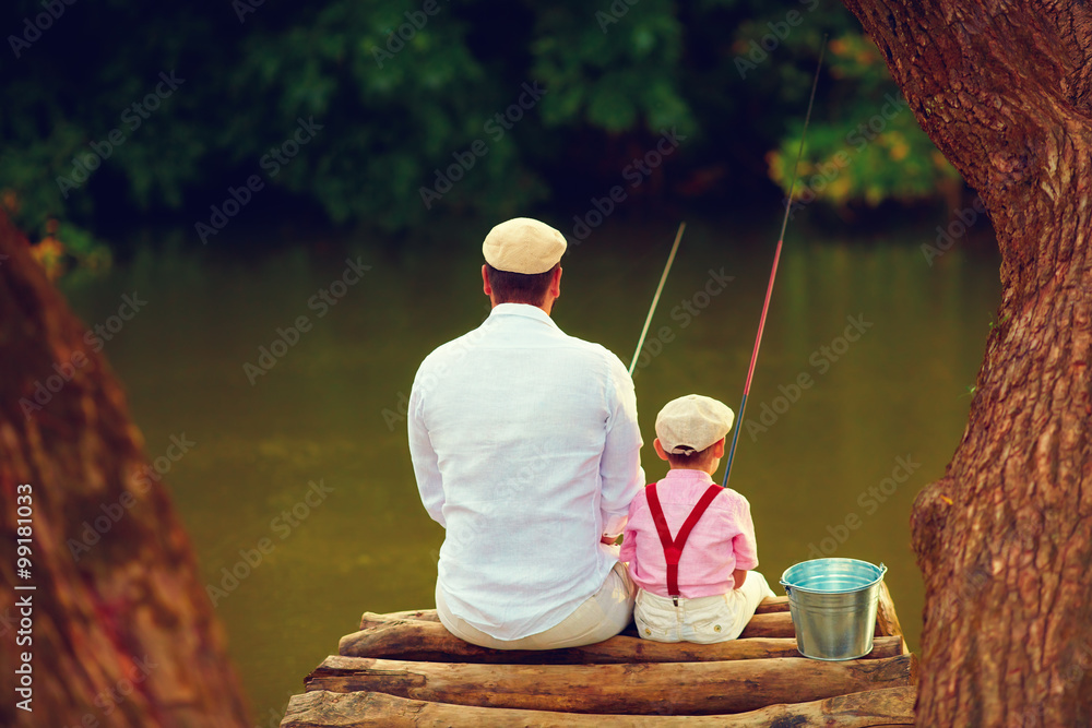cute father and son fishing together among beautiful pristine nature cute father and son fishing together among beautiful pristine nature