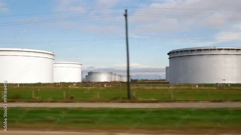 Slow motion driving along road next to a storage tanks standard to the petrochemical industry. Slow motion driving along road next to a storage tanks standard to the petrochemical industry.