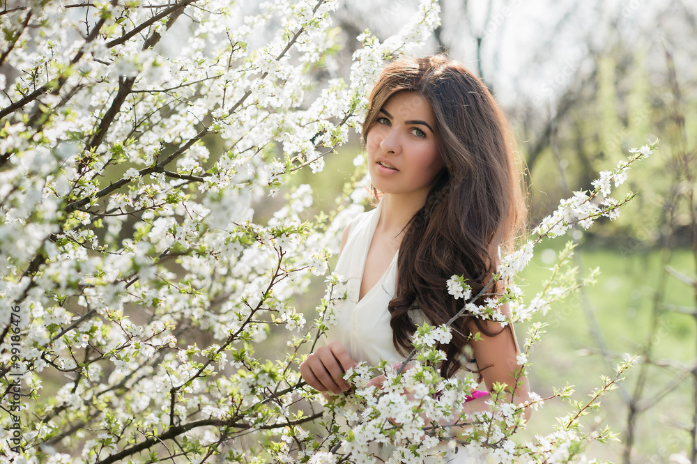 Woman with beautiful hair in the lush spring garden smiling and rejoicing, beauty, makeup, hair Woman with beautiful hair in the lush spring garden smiling and rejoicing, beauty, makeup, hair