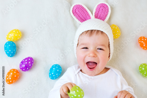 Canvas Print Baby boy in bunny hat lying on green blanket with easter eggs