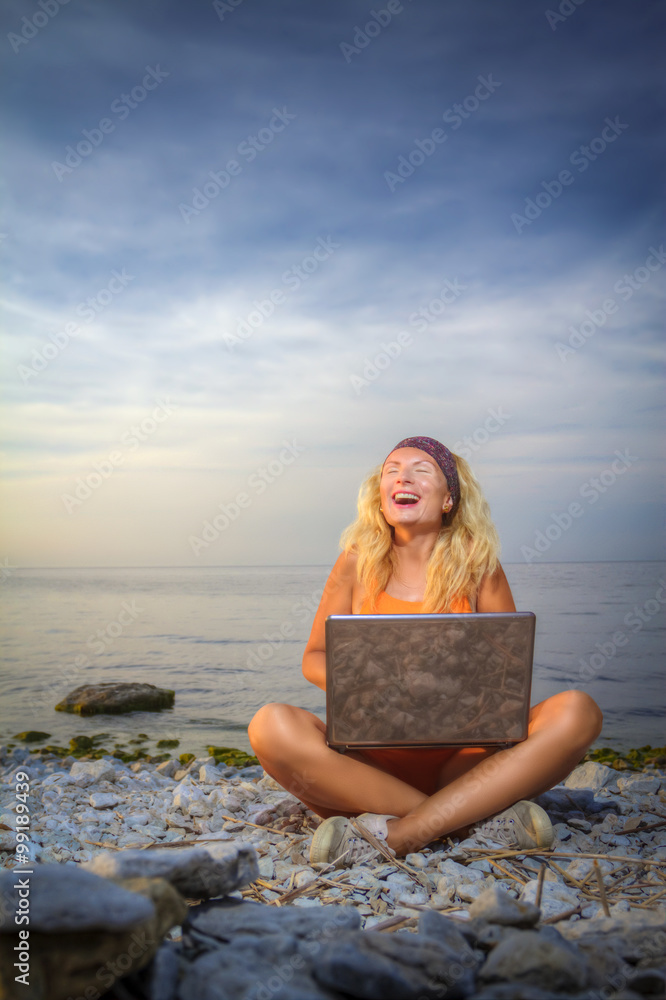 girl laughs looking at a laptop
