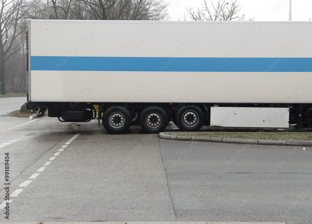 A lorry trailer on a parking with some trees in the background A lorry trailer on a parking with some trees in the background