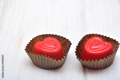 Heart-shaped chocolates on the white background 