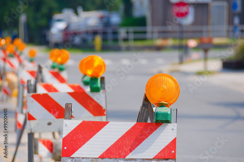 Row of red and white road traffic barricades with yellow lights