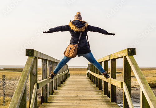 Frau steht auf Holzbrücke photo