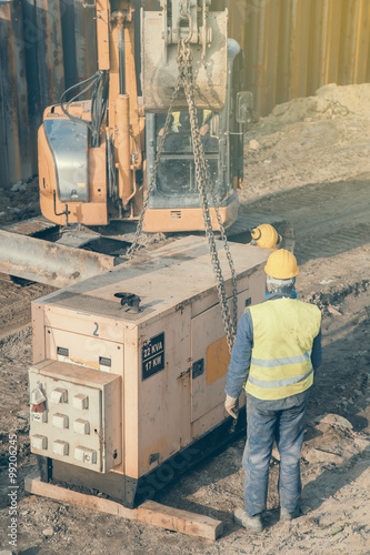 Canvastavla Workers installing electric generator at construction site 2