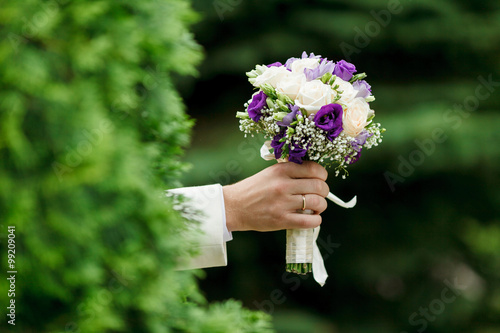 beautiful wedding bouquet in hands of men