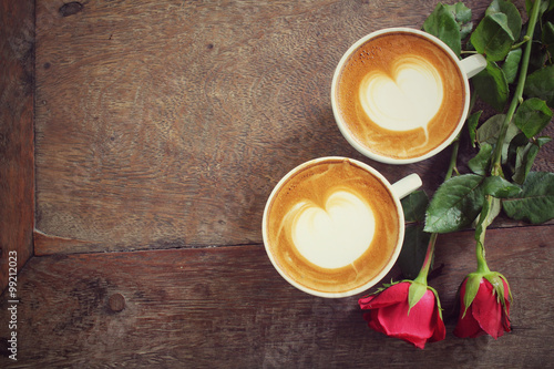 Two cups of latte art coffee with red rose